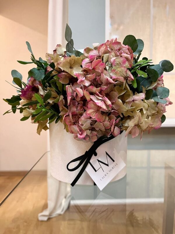 Sombrerera de flores con hortensias preservadas en tonos rosas